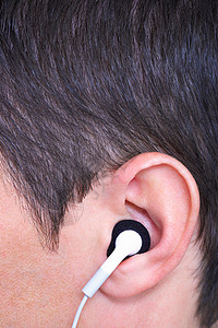 戴耳塞式耳机的耳朵背景图片