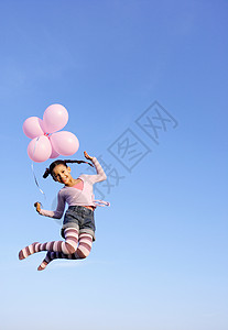 女孩拿着气球在空中跳跃图片