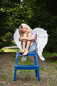 坐在凳子上的翅膀女孩背景图片