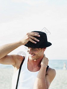 在海滩上戴帽子的男人图片