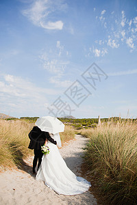 新娘新郎在阳伞下行走背景图片