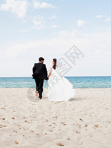 新郎新娘沿着海滩奔跑阳光高清图片素材