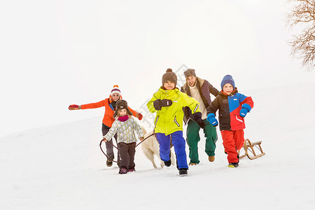 雪地里奔跑的家庭微笑高清图片素材