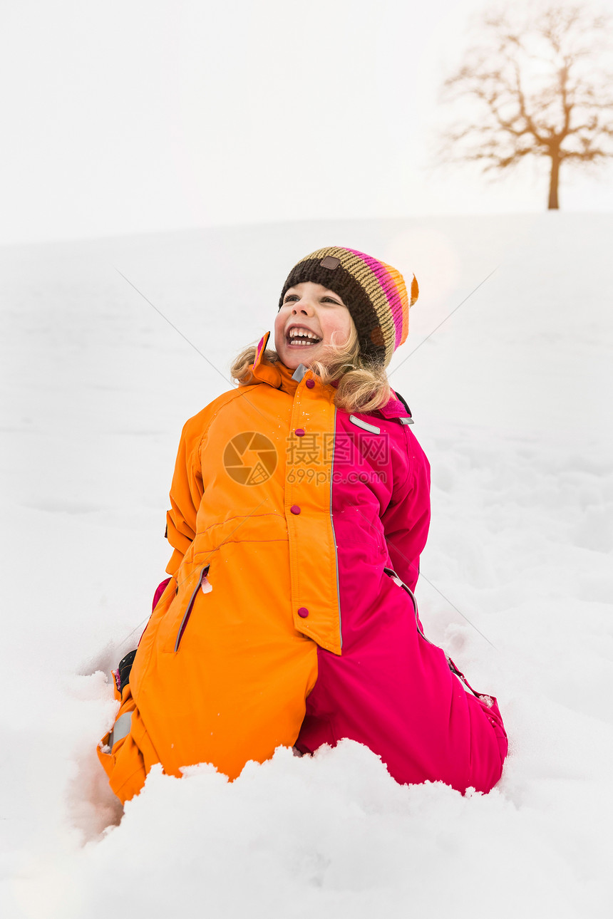 穿雪衣的女孩跪在雪上图片