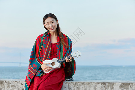 弹琴人物文艺美女海边弹尤克里里背景