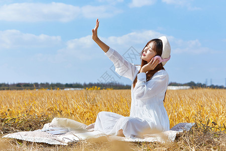 秋天女人文艺美女户外听音乐背景