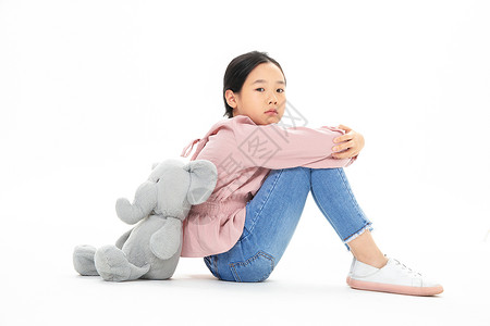 儿童小象玩具和玩具小象背靠背失落的小女孩背景