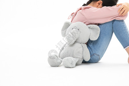 动物的眼泪和玩具小象背靠背哭泣的小女孩背景