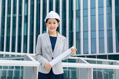 建筑业工人女性建筑工程师拿图纸背景