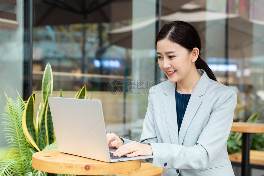 商务女性在咖啡厅用笔记本电脑办公图片