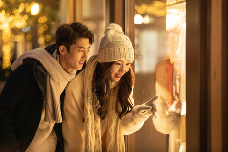 温暖手套冬季情侣购物橱窗前挑选衣服背景