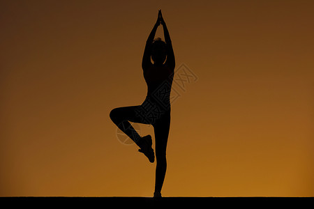 瑜伽运动剪影女性瑜伽夕阳剪影背景