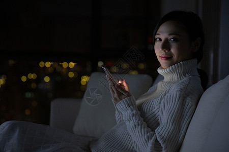 冬季青年女性夜晚玩手机图片