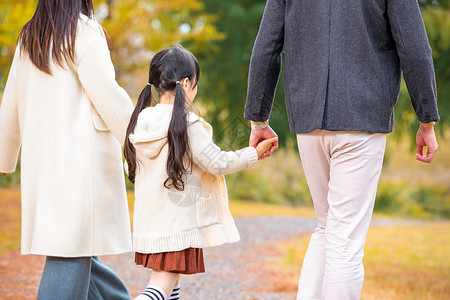 散步的女孩一家人公园散步背影背景