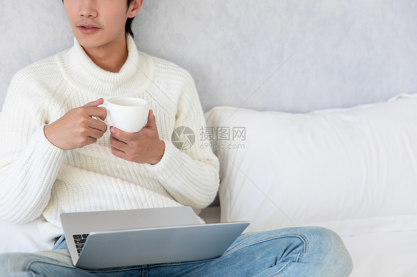 居家男性坐在床上喝咖啡图片