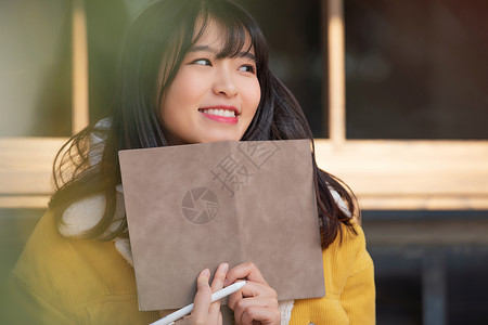 坐着喝咖啡的人坐在咖啡厅学习的女大学生背景