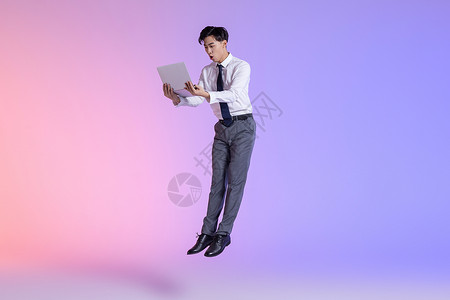 商务男性拿平板电脑跳跃图片