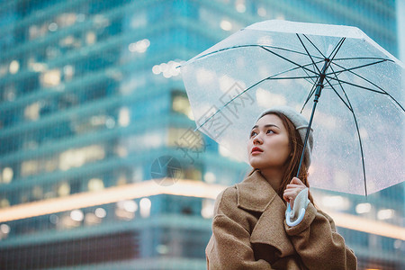 冬季女性户外下雨天撑伞看远方打伞高清图片素材