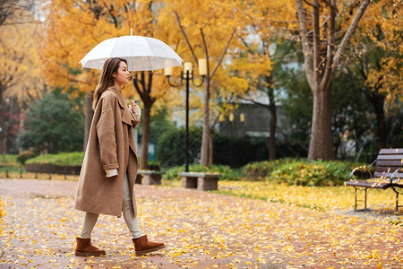 秋季雨天美女撑伞公园散步亚洲人高清图片素材