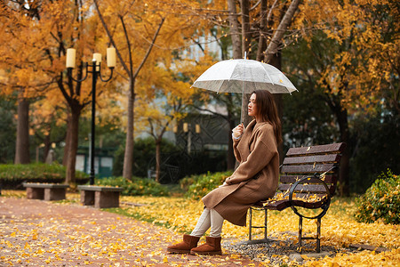 秋季雨天美女公园撑伞图片