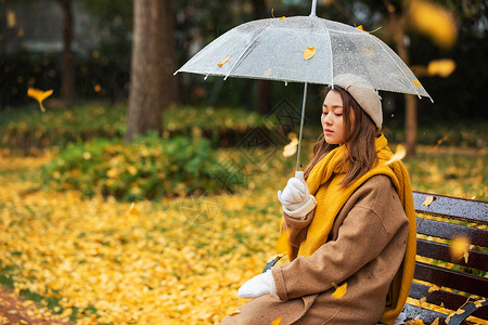 秋季雨天文艺美女公园撑伞背景图片