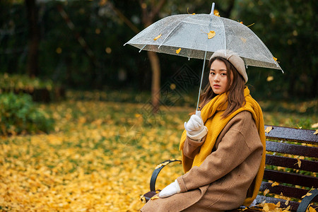 秋季雨天文艺美女公园撑伞背景图片