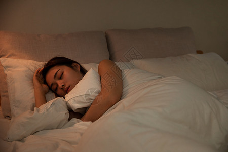 夜晚女性抱被子睡觉图片