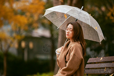 撑伞少女秋季雨天美女银杏落叶撑伞背景