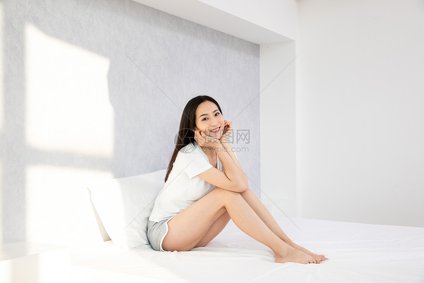 青年居家女性坐在床上休息图片