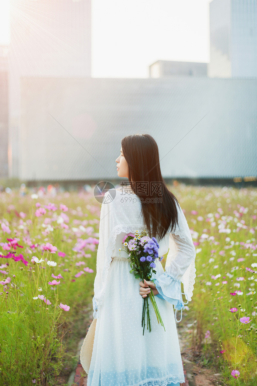 花海少女手拿花束背影图片