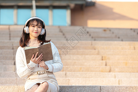 坐在台阶在校园台阶上听音乐休息的大学生背景