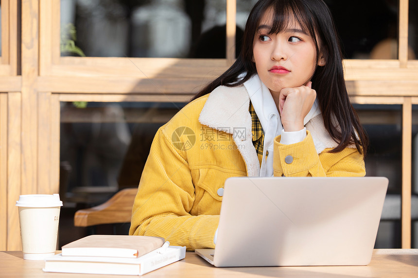 在咖啡馆复习功课的甜美女孩图片