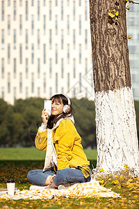 坐在银杏树下听音乐的女孩 图片