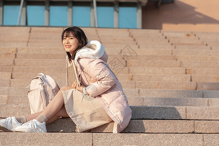 坐在户外台阶上的女大学生图片