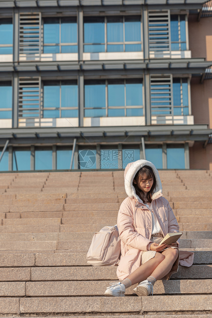 坐在台阶上阅读的女大学生图片