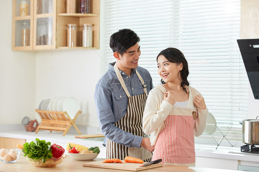 年轻男士给妻子系戴围裙图片