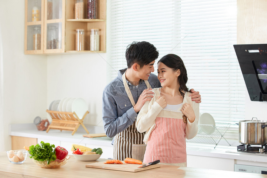 年轻男士给妻子系戴围裙图片