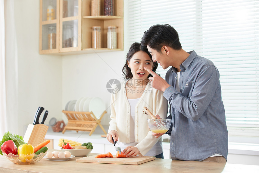 年轻夫妻在厨房甜蜜互动图片