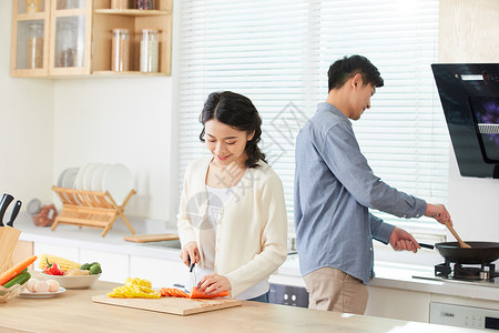 做饭的情侣年轻夫妻在厨房一起做菜背景