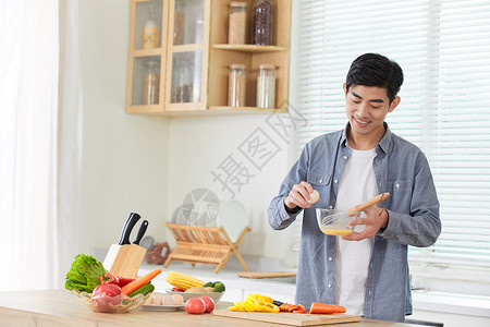 年轻男士在厨房打蛋图片