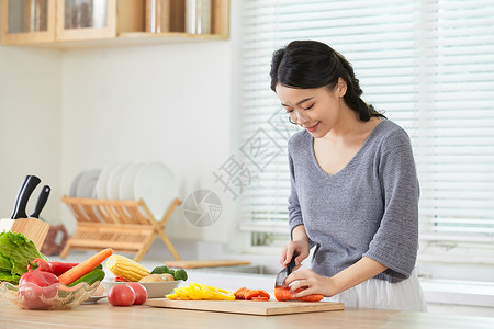 年轻女士在厨房切菜下厨高清图片素材