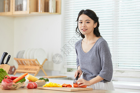 年轻女士在厨房切菜中国人高清图片素材