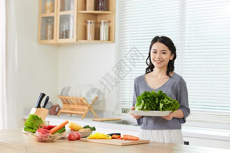 年轻女士在厨房备菜做菜高清图片素材