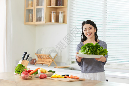 年轻女士在厨房备菜图片