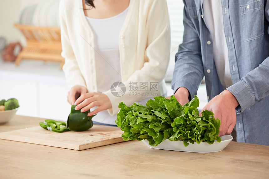 年轻夫妻在厨房一起备菜图片