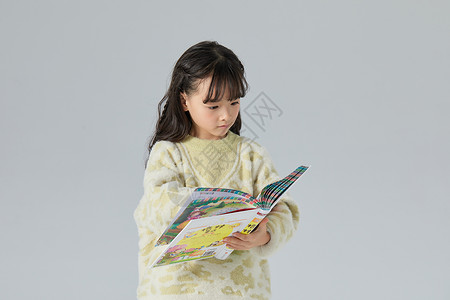 小女孩手捧书本看书背景图片