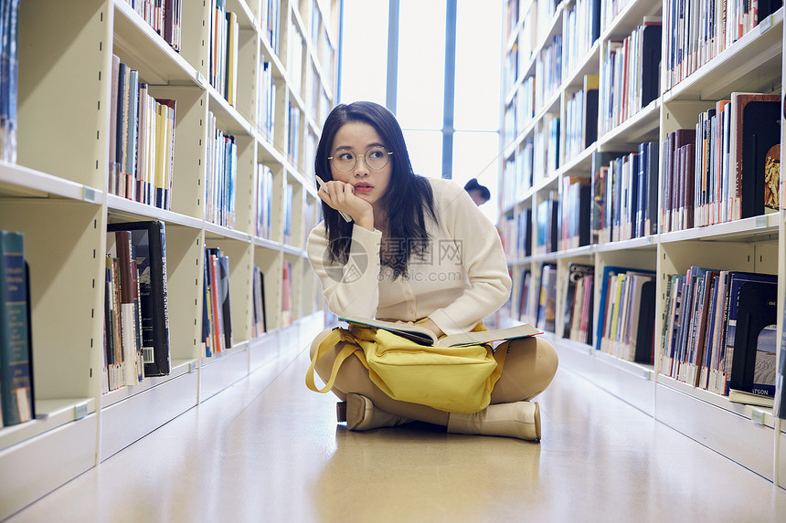 女学生在图书馆看书思考图片