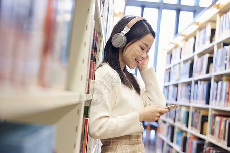 女学生在图书馆听音乐高清图片