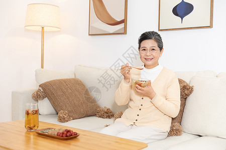 叻沙汤老奶奶坐沙发上喝银耳汤背景