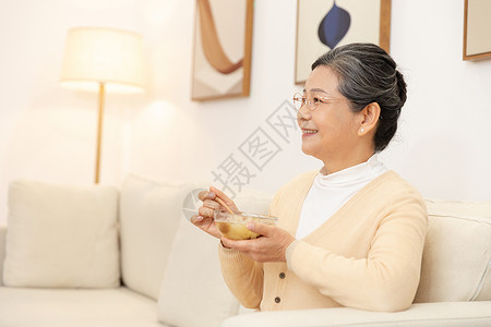 叻沙汤老奶奶坐沙发上喝银耳汤背景